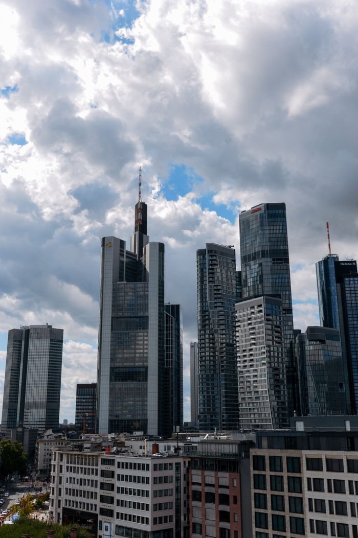 Skyline of Frankfurt's financial district under a partly cloudy sky.