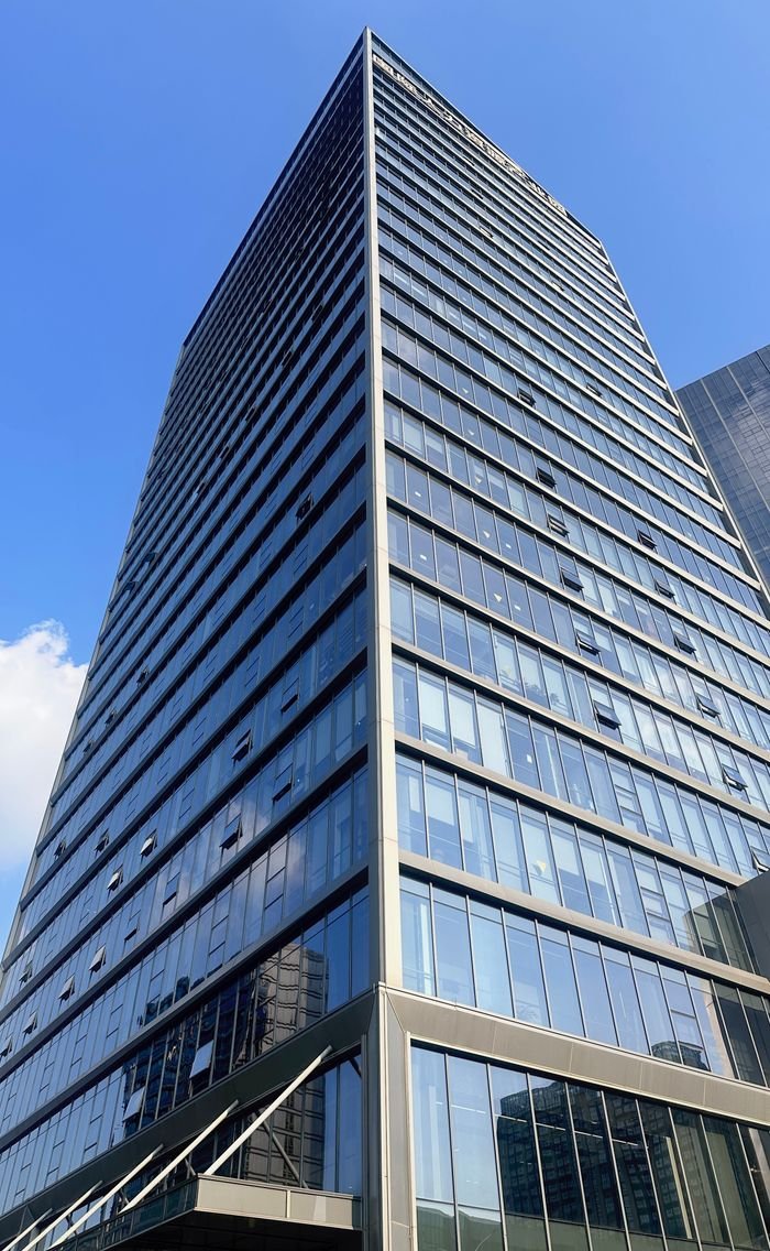 A striking view of a modern skyscraper reaching into a clear blue sky, embodying urban architecture.