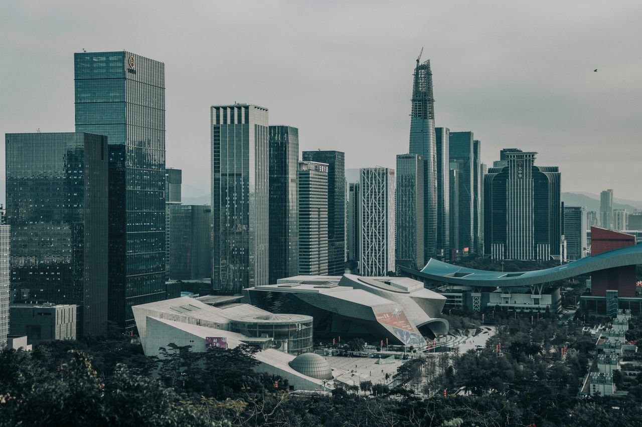 A modern urban skyline featuring numerous skyscrapers under a gloomy sky.